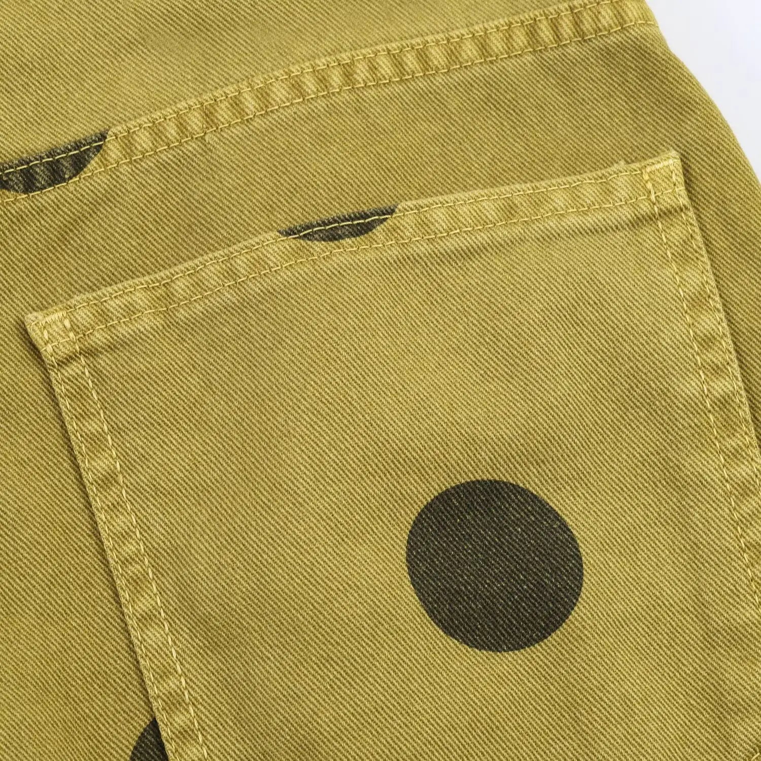 Olivgrüne Denim-Hosen mit weitem Bein mit einem kräftigen schwarzen Polka-Dot-Muster und einem Design mit hoher Taille.