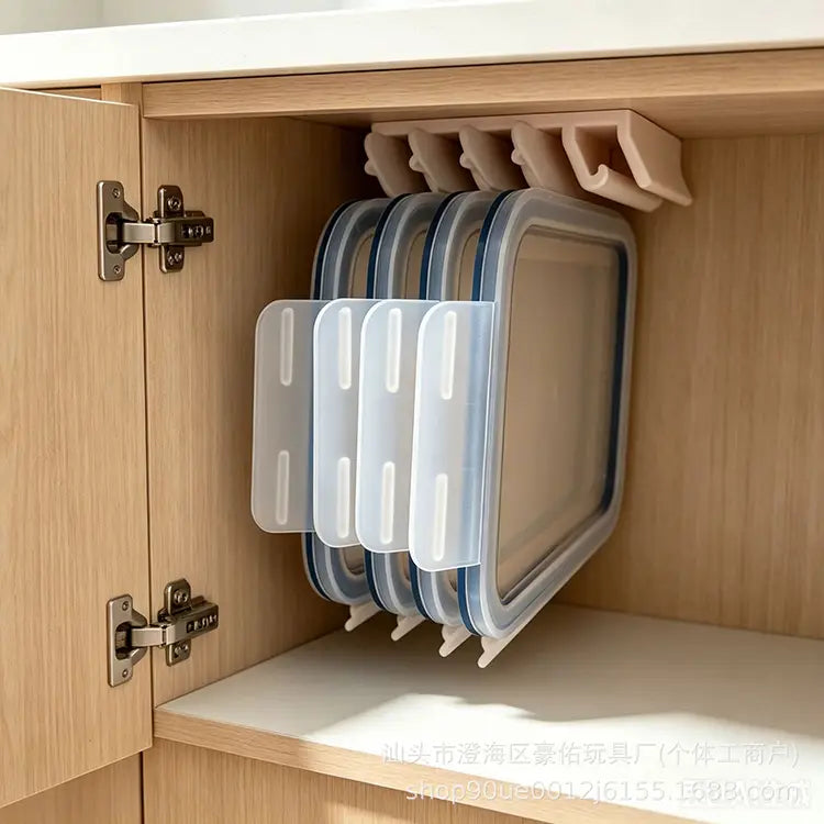 Boîtes de rangement alimentaires en plastique transparent avec des couvercles à rebord bleu, empilées avec soin dans un porte-couvercles peu encombrant pour un usage de cuisine organisé.