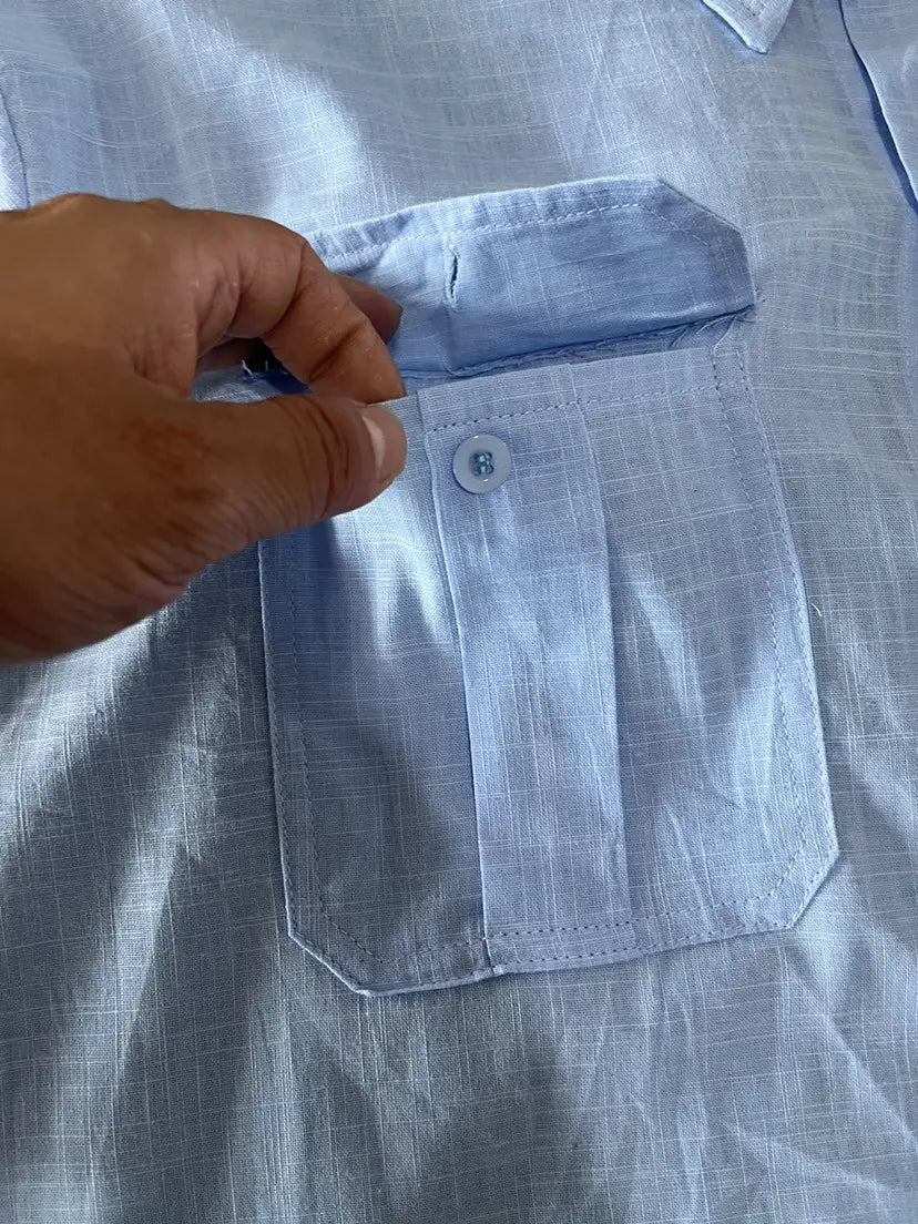 Men linen short sleeve shirt in light blue with a subtle woven texture and a single-button chest pocket designed for casual summer wear.
