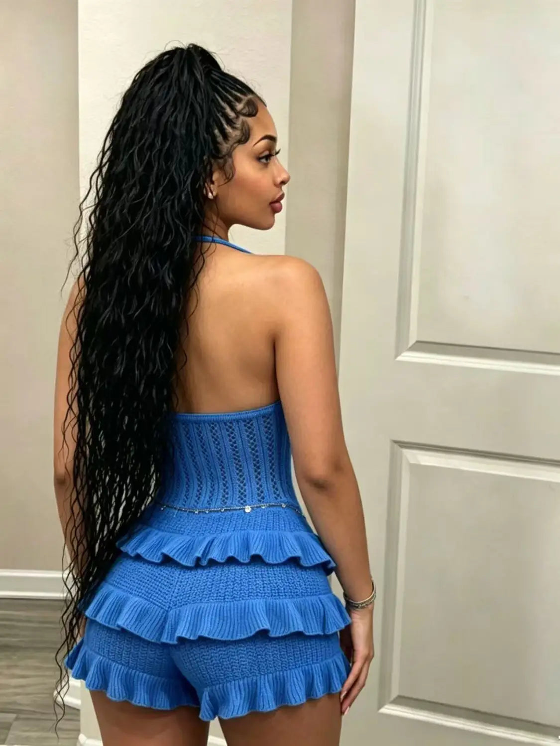 A vibrant blue knitted ruffle halter romper summer playsuit featuring a halter top with intricate lace detailing and matching ruffled shorts.
