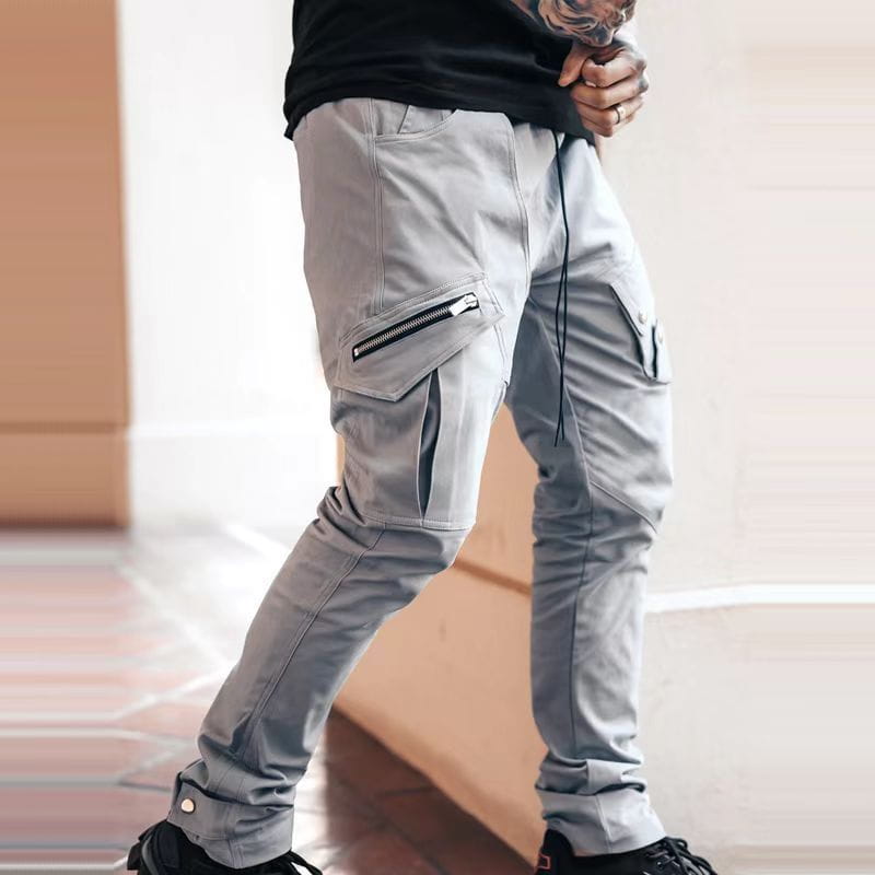 Herren-Tactical-Cargohosen in Grau mit mehreren Taschen, einschließlich eines Reißverschlussverschlusses, sowie einem Kordel-Detail, für den Freizeit- und funktionalen Gebrauch ausgelegt.