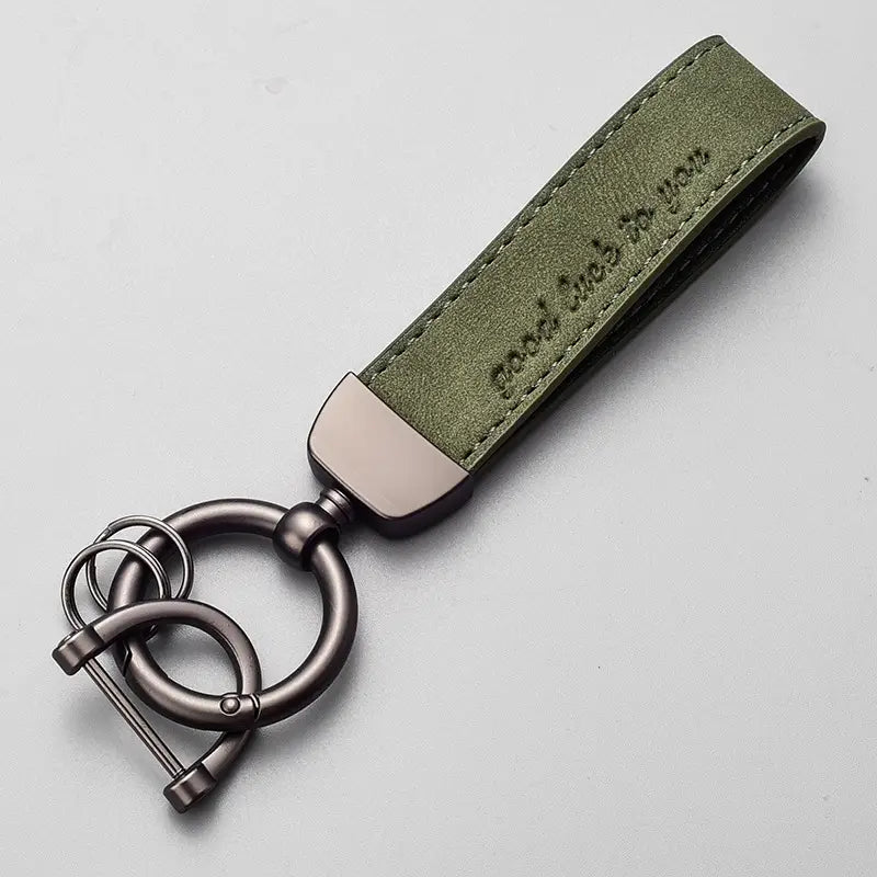Olive green leather car keychain with a brushed metal ring and clasp featuring the engraved phrase good luck to you in a luxury genuine leather key ring.