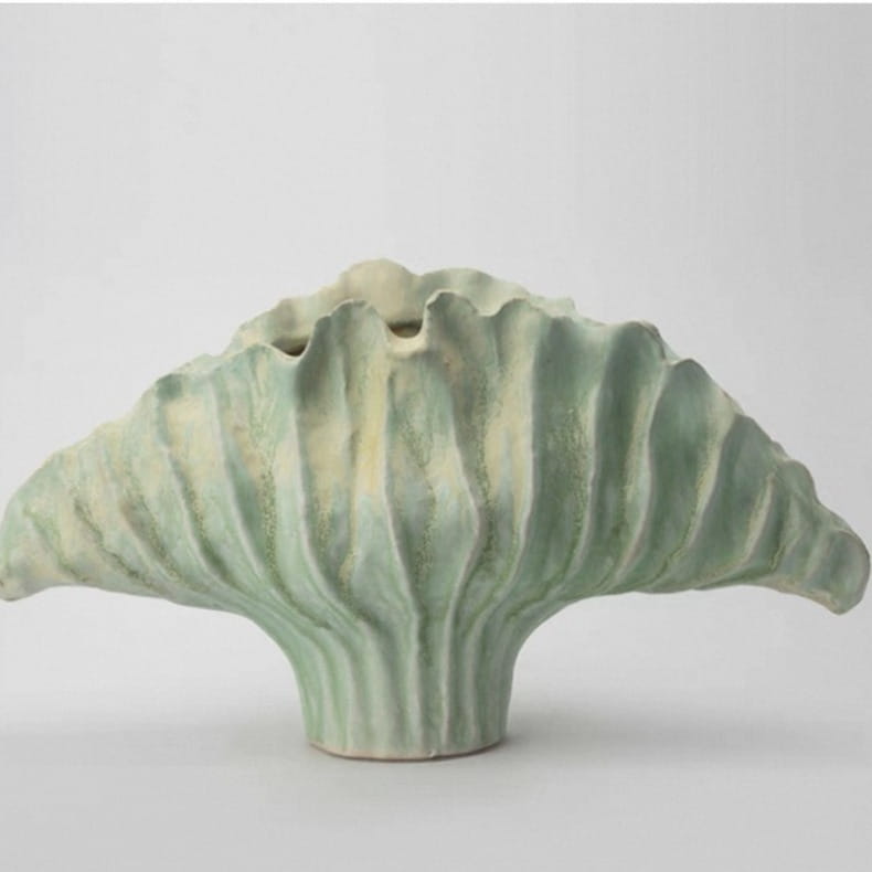 Un vase à fleurs en céramique à l’allure sculpturale, dans des tons vert doux et crème, doté d’une forme striée évoquant une feuille, conçu pour des effets d’exposition de poterie décorative moderne, dans les dimensions 37 x 12 x 23 cm et 45 x 14 x 25 cm