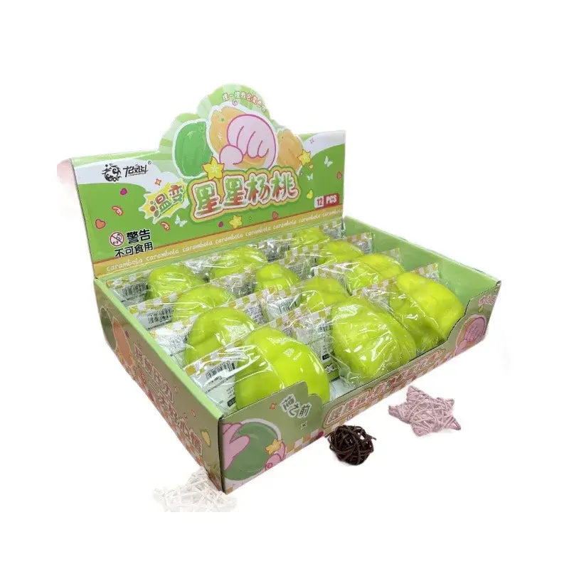 Caramelos de juguete blando con forma de estrella y plástico brillante verde, que cambia de temperatura, envasados en plástico transparente dentro de una caja de exhibición colorida.