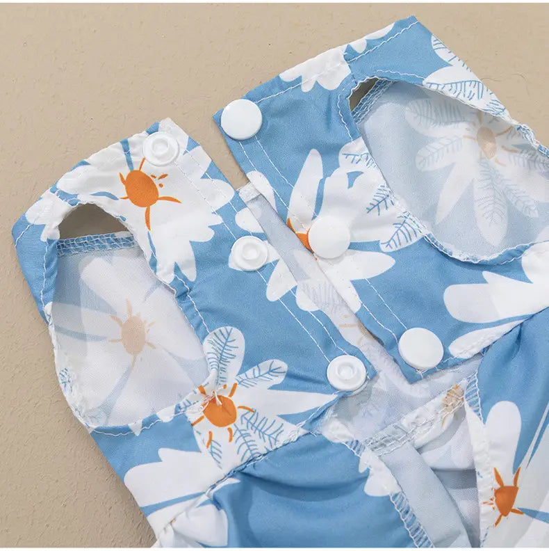 floral dog princess dress with bow featuring a blue and white floral-patterned baby diaper with orange insect motifs and snap closures.