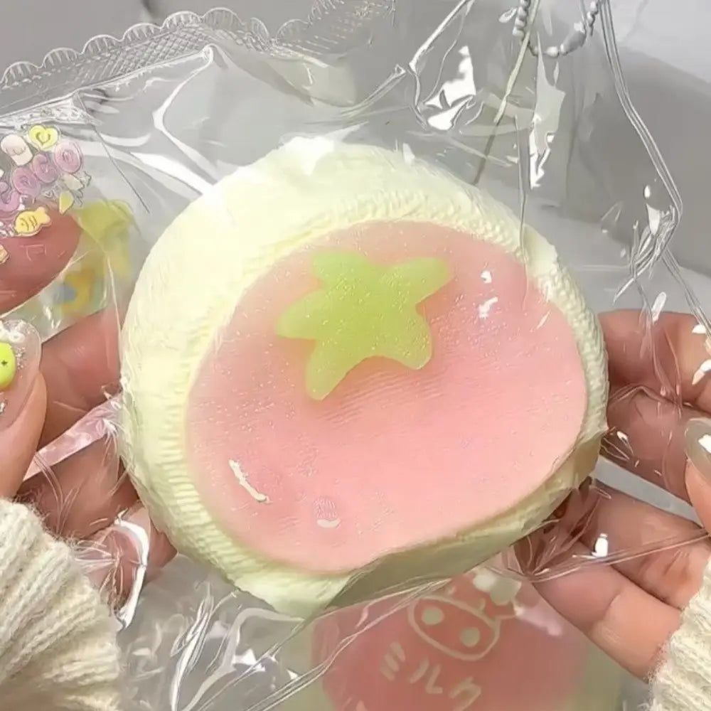 Un jouet antistress « squeeze » de type dessert kawaii sensoriel, qui remonte lentement, en rose pastel doux et jaune pâle, avec un motif d’étoile de couleur vert clair pour soulager le stress sensoriel.