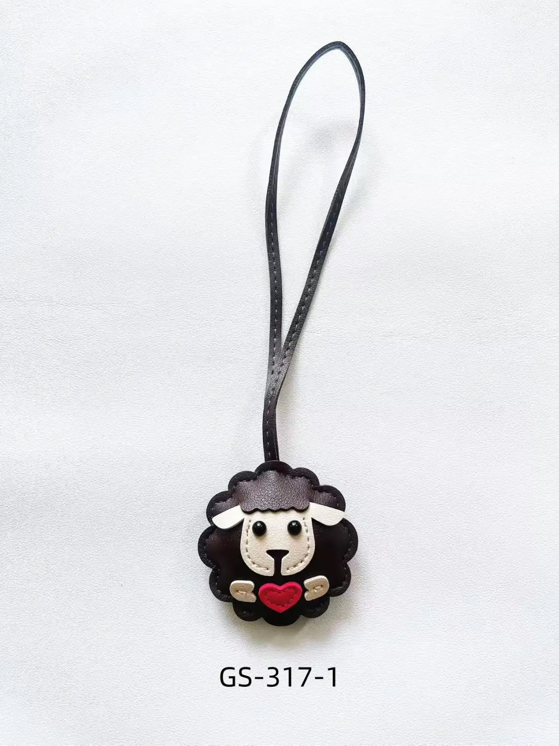 Black leather sheep keychain with white face red heart and black strap designed as a cute animal bag charm.