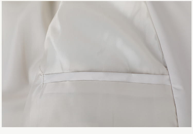 Chaqueta cortavientos ligera para hombre con cuello vuelto, confeccionada con tejido de satén blanco, que presenta un acabado brillante y liso y un brillo sutil.