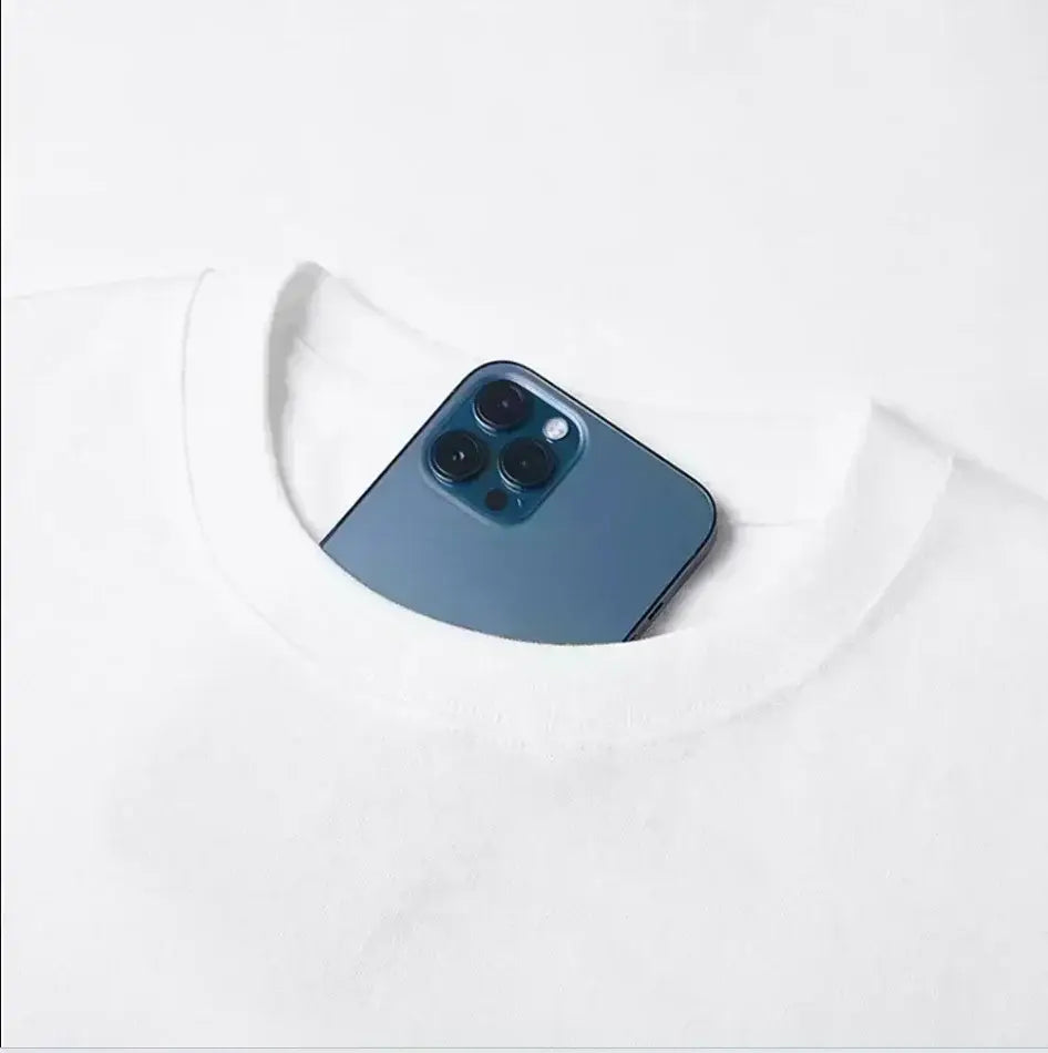 a sleek deep blue iphone 12 pro with a glossy finish and triple-camera system visible from the neckline of a white unisex cotton t-shirt featuring the office cast print