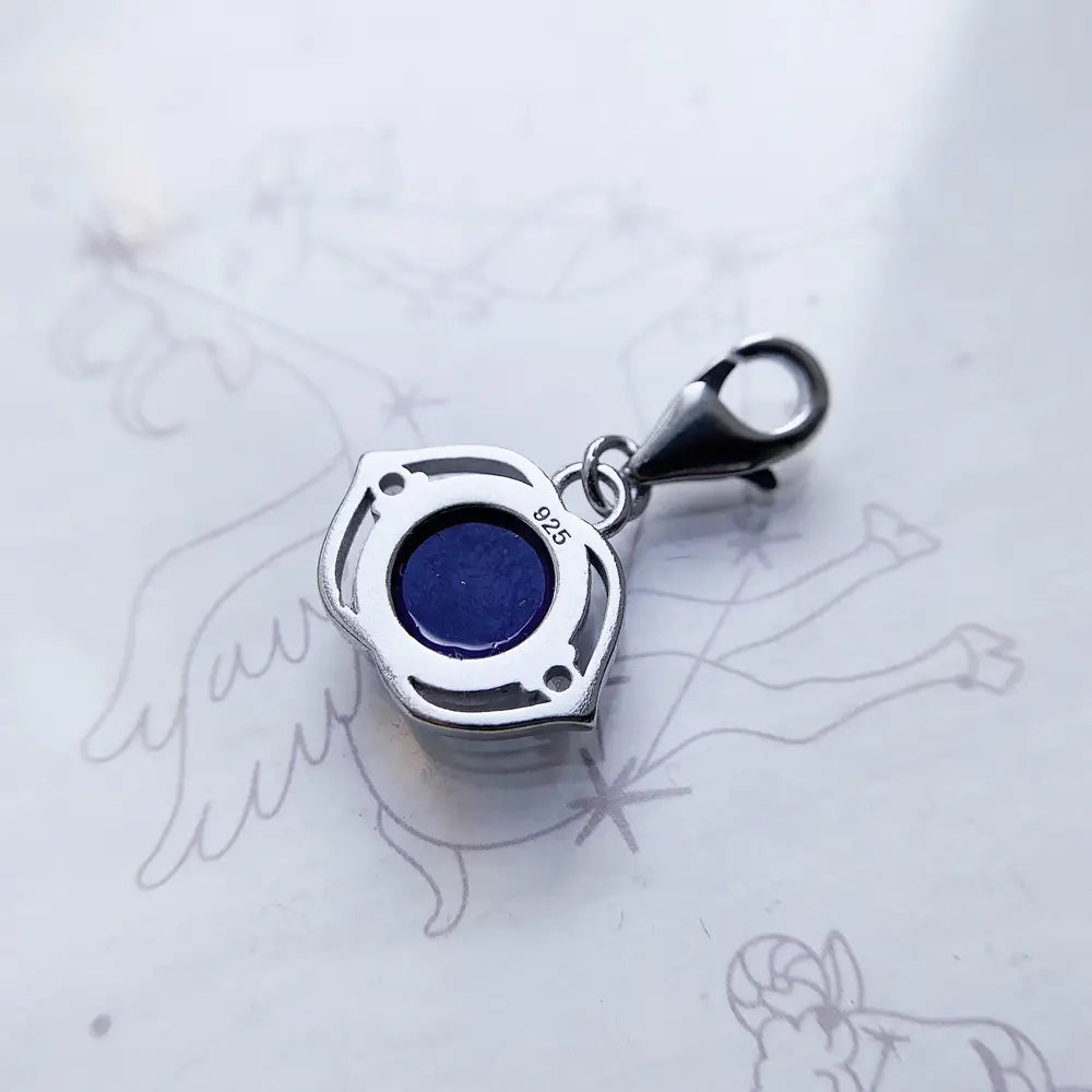 Colgante de encanto de plata de ley Flor de Loto Azul, que presenta una piedra de lapislázuli azul profundo engastada en un intrincado marco de plata de ley 925 con forma hexagonal.