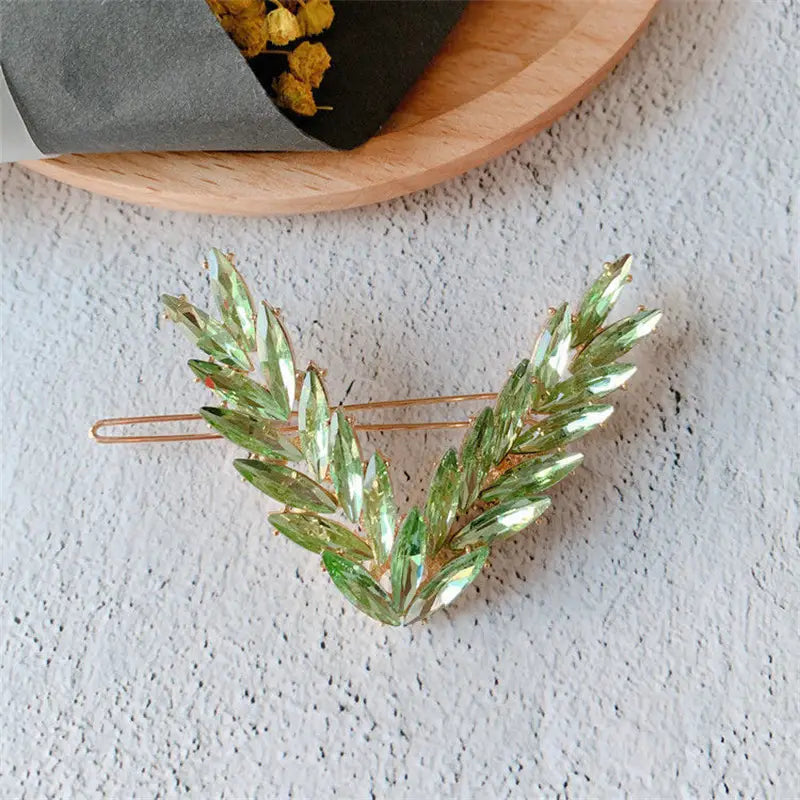 a delicate green crystal leaf hair clip with a gold-tone metal base from the crystal v shape hair clip set