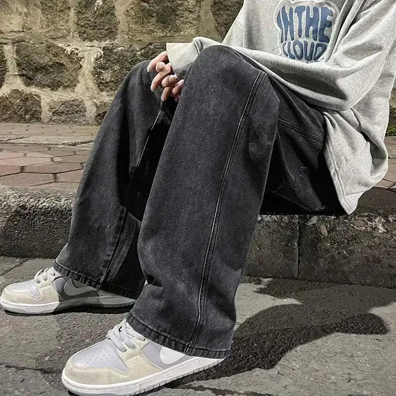Jeans en denim à lavage foncé à jambes larges pour hommes, coupe décontractée à jambe droite et détails de surpiqûres visibles, conçus pour un style streetwear coréen ample.
