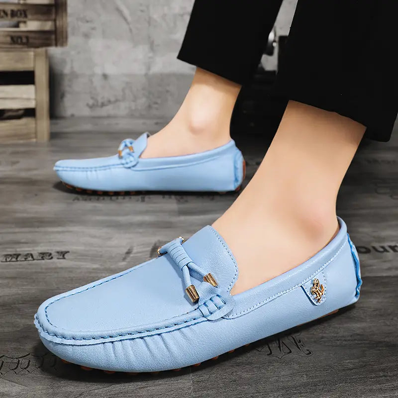 Chaussures à enfiler habillées en cuir suédé bleu clair pour hommes, se portant sans effort avec des chaussures décontractées, avec des accents métalliques ton or et des détails de gland décoratif.