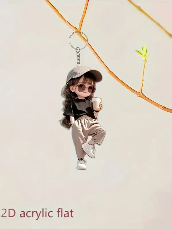 Cute acrylic girl keychain featuring a cartoon pendant of a girl with long brown hair wearing a gray cap and sunglasses while holding a white cup.