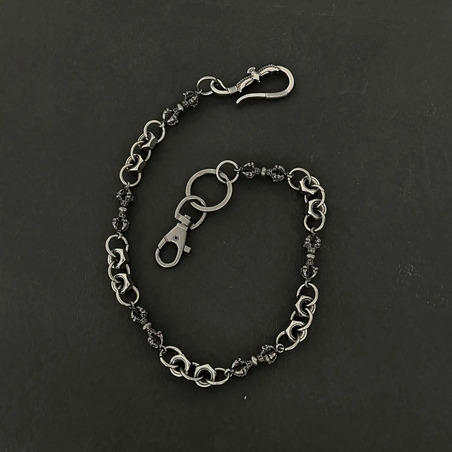 Men eagle punk trouser chain featuring dark metallic links with skull-shaped beads and a silver-toned lobster clasp for heavy metal wallet accessory use.