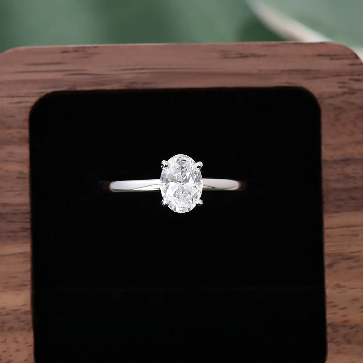 Bague à anneau à tons argent, au style épuré, dans un ensemble de bague de fiançailles en diamant de laboratoire ovale ton or, mettant en avant un diamant ovale proéminent maintenu par quatre griffes.