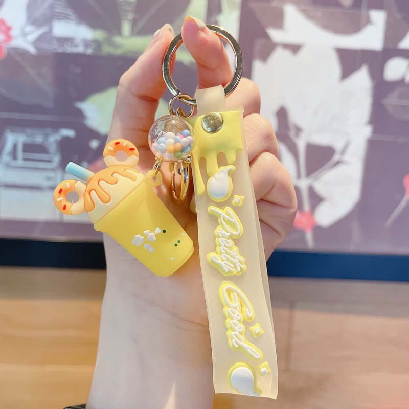 Yellow silicone boba tea keychain with a donut-shaped top and a colorful bead-filled clear ball charm in an ice cream keychain personalized pvc hanger.