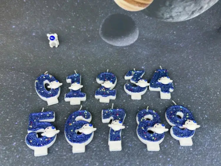 Velas azules con brillo temáticas de astronautas para cumpleaños, con bases blancas, utilizadas como adornos para pastel de fiesta planetaria de velas de cumpleaños numerales del espacio.