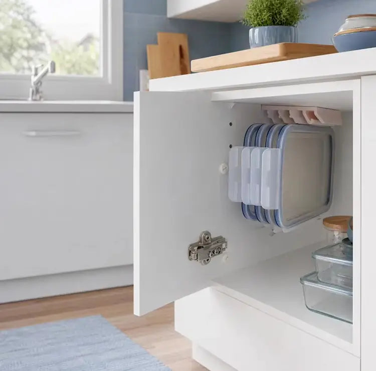 Boîtes de rangement alimentaires en plastique transparent avec des couvercles bleus, empilées avec soin dans une armoire à l’aide d’un support de rangement en plastique pour couvercles peu encombrant.