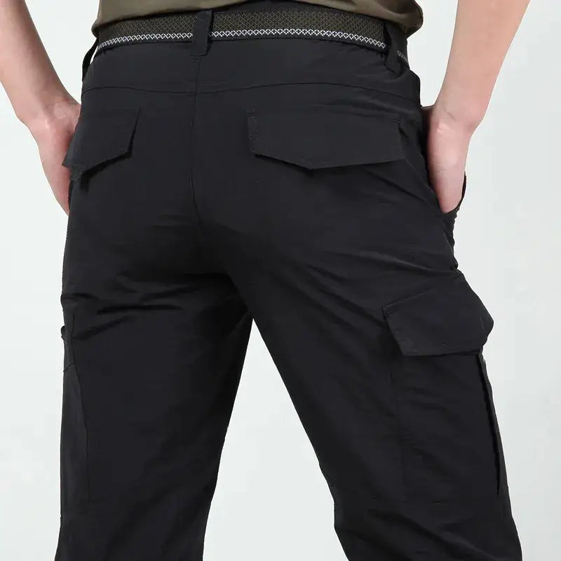 pantalons cargo tactiques légers pour homme en noir, dotés de plusieurs poches et de détails de boucle de ceinture texturée.
