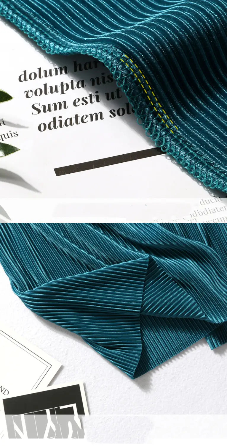 tealfarbene weit geschnittene plissierte Sommerhose für Damen mit elastischem Bund und gerippter Stoffstruktur sowie kontrastierenden gelben Ziernähten.