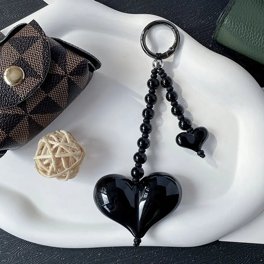Porte-clés en forme de cœur brillant noir avec une chaîne à perles et un petit pendentif en forme de cœur suspendu, destiné à servir de pendentif pour sac à perles.