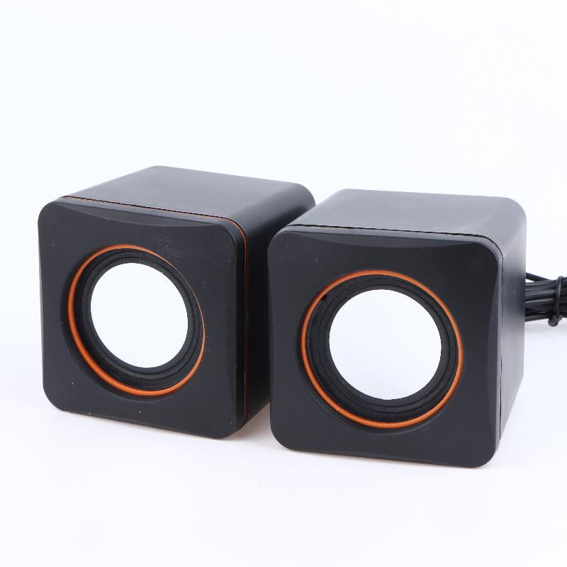Schwarze würfelförmige USB-Computerspeaker mit orangefarben akzentuierten kreisförmigen Treibern und integriertem Mikrofon zur Verwendung am Desktop.