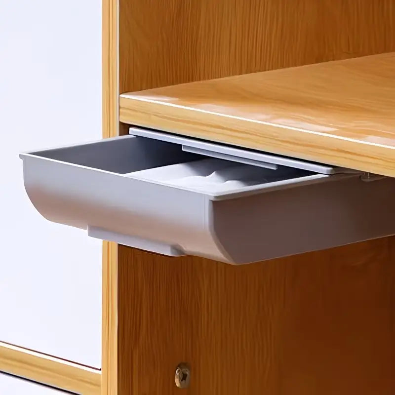Boîte de rangement sous le bureau à tiroir coulissant comprenant un tiroir inférieur en plastique argenté, à l’avant incurvé et mécanisme de glissement intégré.