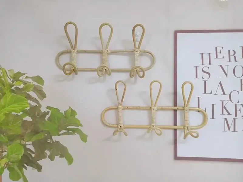 Beiger Rattan-Kinder-Wandhaken zur Aufbewahrung von Kleidung mit drei Haken sowie geflochtenen Details zur wandmontierten Organisation.
