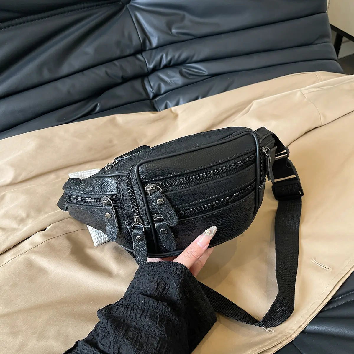 Schwarze Gürteltasche aus echtem Leder mit strukturierter Oberfläche, mehreren Reißverschlüssen und verstellbarem Riemen für die Verwendung als Crossbody- oder Bauchtasche