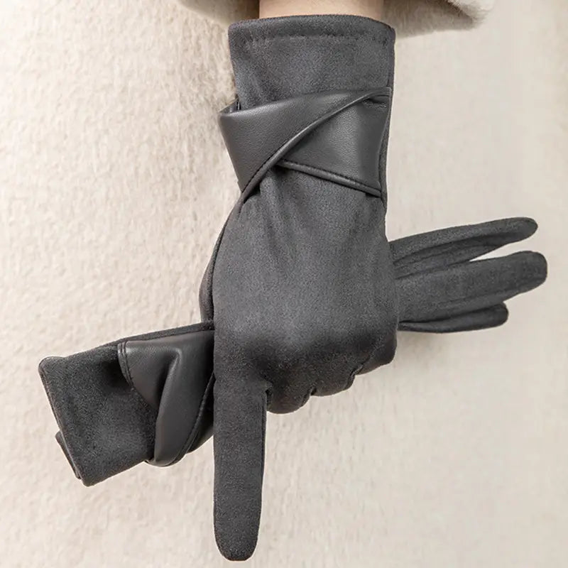 Guantes de invierno para mujer con pantalla táctil en gris oscuro, con textura tipo ante y acentos de muñeca de cuero lisa, con un diseño de correa cruzada elegante, mostrados desde el lado posterior