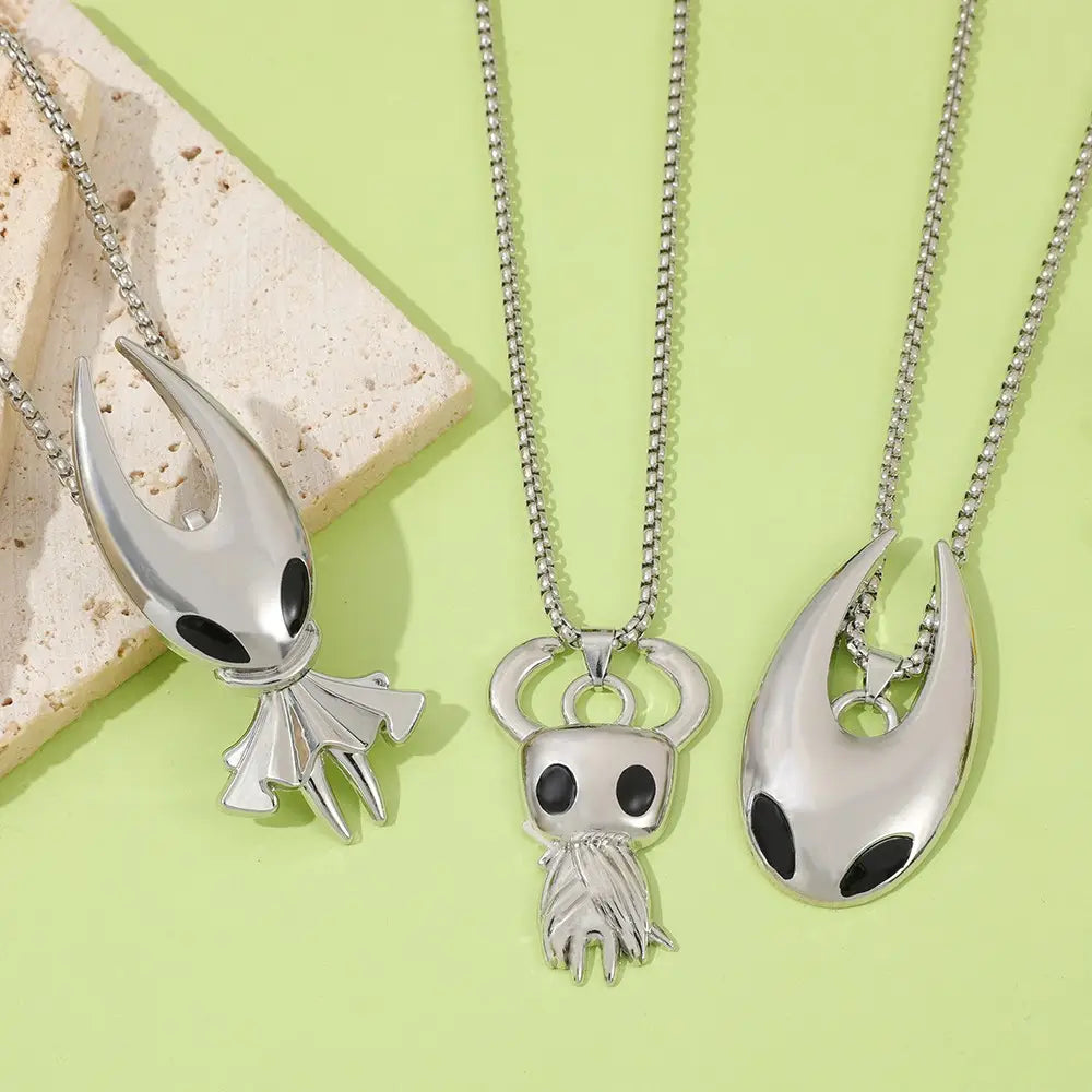 Colliers de jeu en pendentif argenté de chevalier creux présentant des designs distinctifs avec des accents d’yeux noirs et des finitions métalliques sur des chaînes