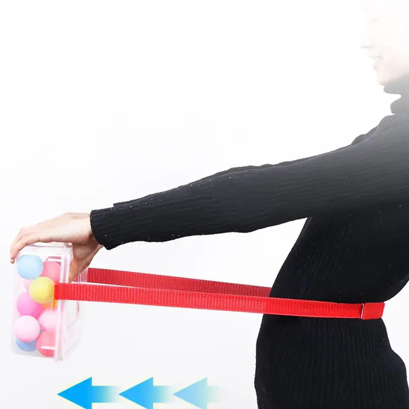 Shaking swing balls party game set featuring a red elastic resistance band with a clear plastic container filled with colorful balls attached to one end.