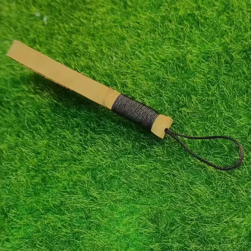 Leather weave lanyard keychain car key holder featuring a tan leather-handled wooden stick with a black braided cord loop at the end.
