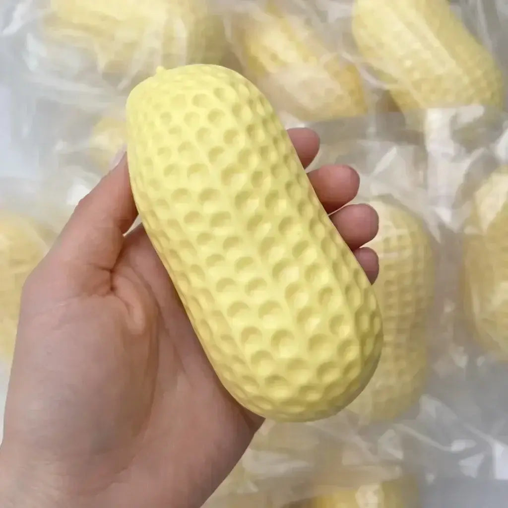 Un jouet à mâcher et à malaxer en forme de fromage en forme de cacahuète, texturé jaune pâle, fabriqué en silicone souple, conçu pour soulager le stress et apaiser le stress lié au jouet.