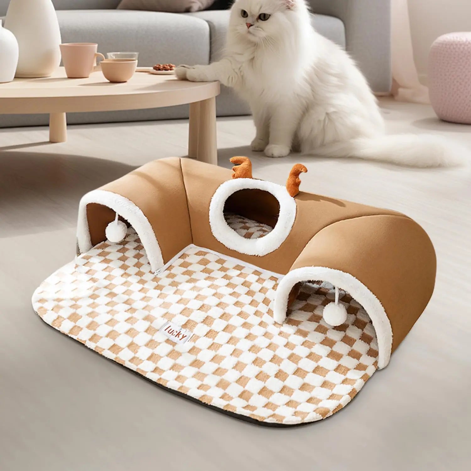 tan and white checkered cat tunnel bed made of plush soft material featuring small orange antler decorations in a cat tunnel bed plush corner hideaway with antlers design