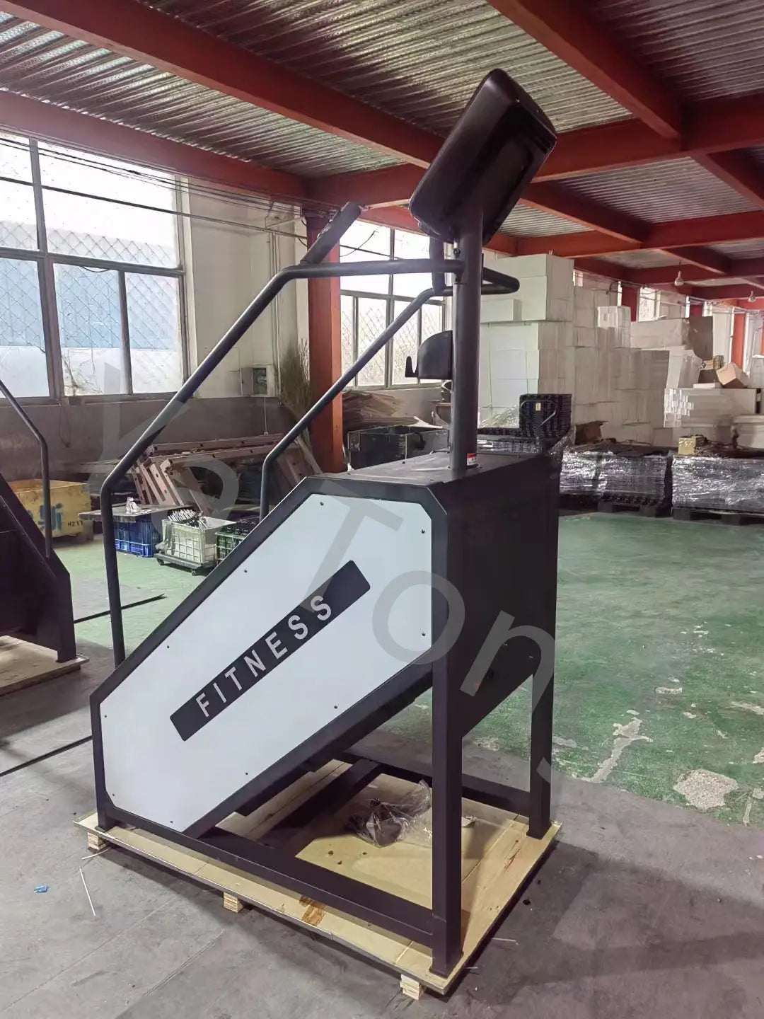Commercial stair climber machine cardio stepmill in black and white featuring a bold fitness logo on its side.