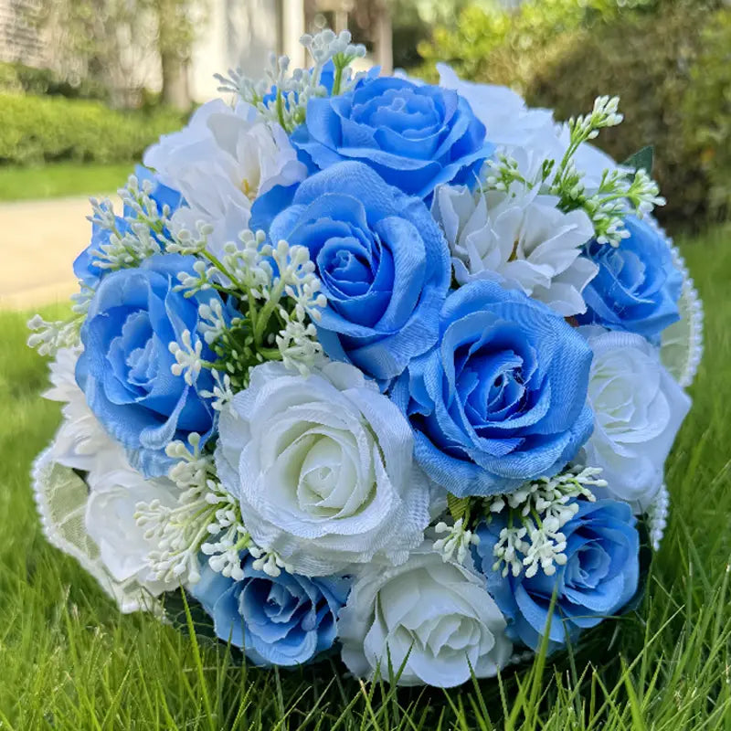 A delicate white silk rose wedding bouquet features artificial blue and white roses accented with tiny greenery, lace, and pearls.