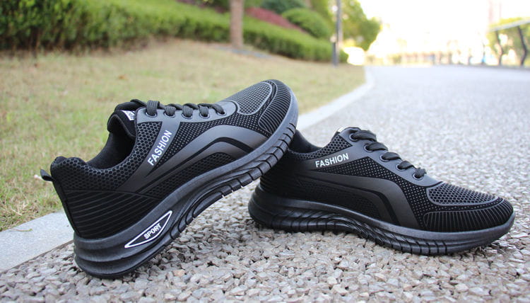 Men breathable athletic sneakers running shoes in black mesh with fashion and sport branding and textured rubber soles designed for running and training.