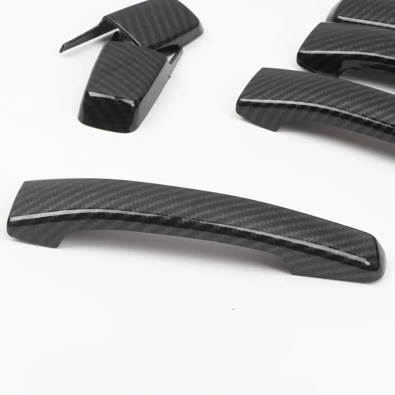 Caches de poignées de porte de voiture à texture en fibre de carbone noire pour la garniture de poignée de porte en chrome Mitsubishi Pajero 2007 à 2021, présentés depuis l’arrière.