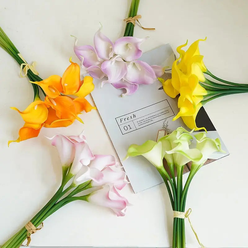 bundles of artificial calla lily flower bouquet in yellow pink lavender and pale green with realistic petals and tied green stems for home decor