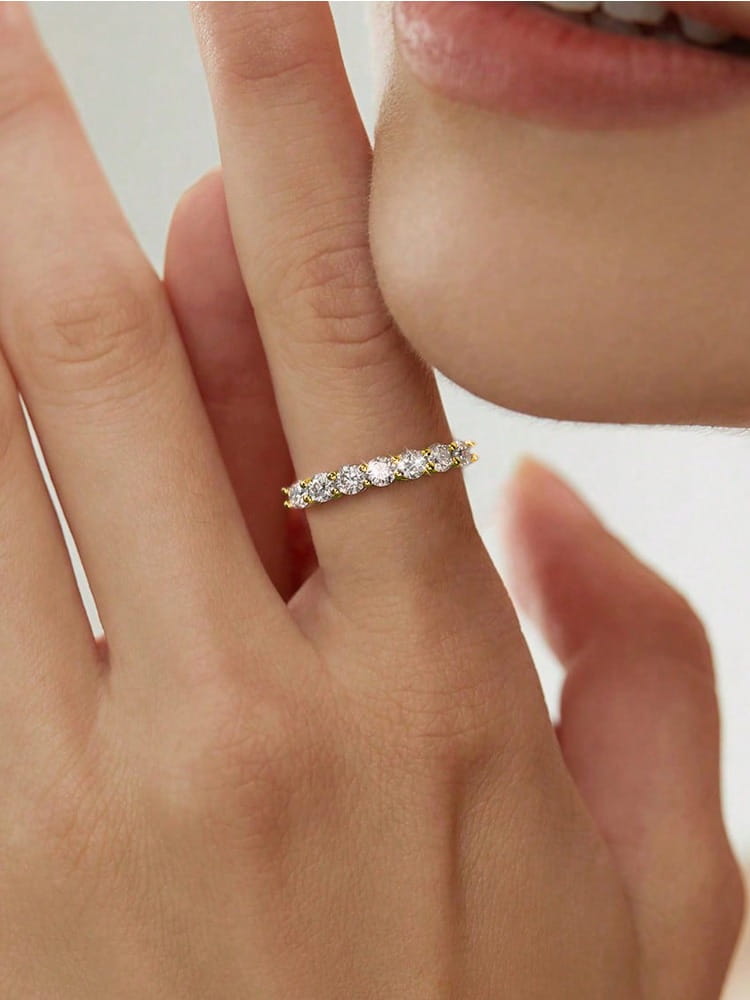 A delicate sterling silver zircon ring for women featuring a gold band adorned with a row of sparkling round-cut diamonds.