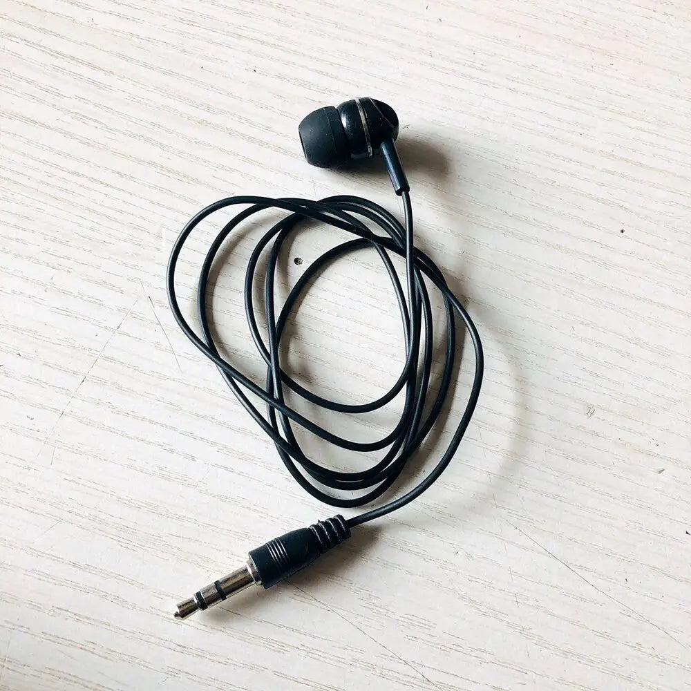 Écouteurs filaires noirs avec embouts en silicone souple et câble spiralé, avec une prise audio filaire standard 3,5 mm pour un usage confortable avec les appareils mp3 mp4.