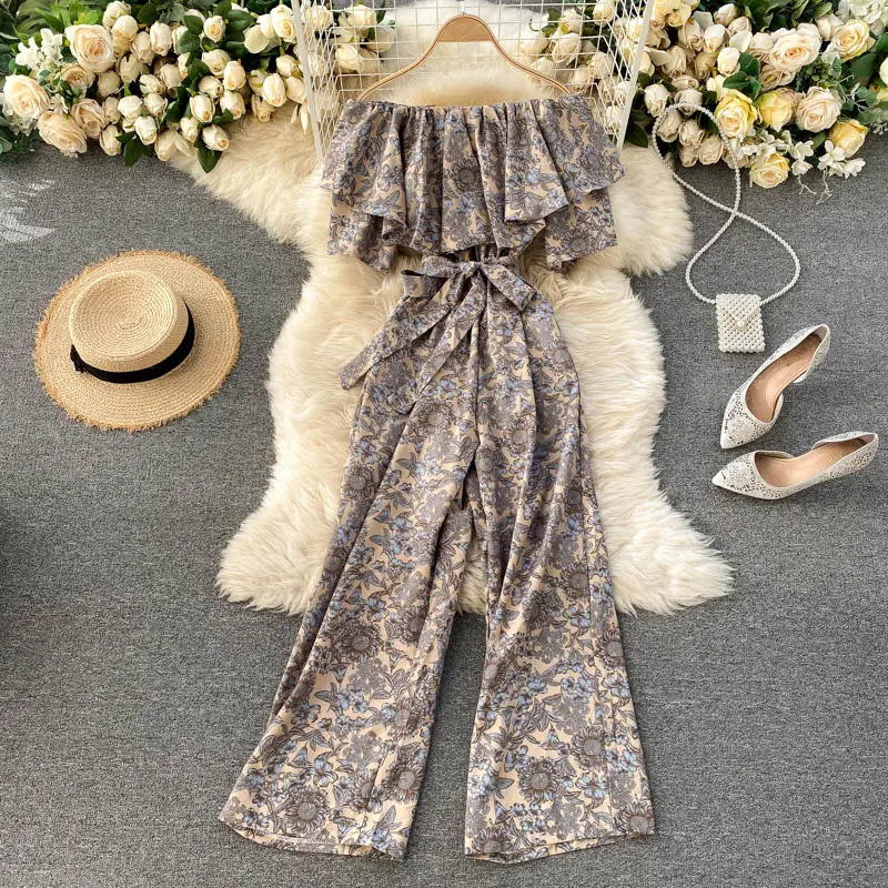 Enterizo de pierna ancha floral con escote tipo bardot y caída fluida en tonos apagados, con volantes superpuestos y cinturilla atada para un aspecto elegante