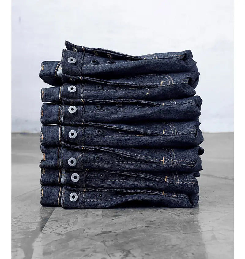 Lot de jeans en denim selvedge slim droit 16 oz « Red Tornado » indigo rouge foncé avec détails de boutons blancs.