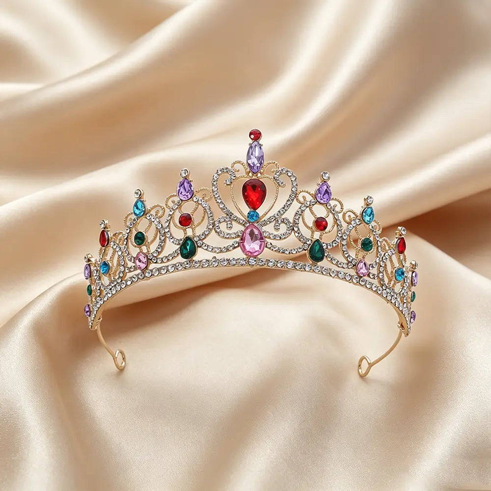 Un accessoire de coiffure de mariée en couronne de diadème baroque en strass doré, présentant un diadème doré étincelant, orné de pierres précieuses colorées et de détails de filigrane complexes.