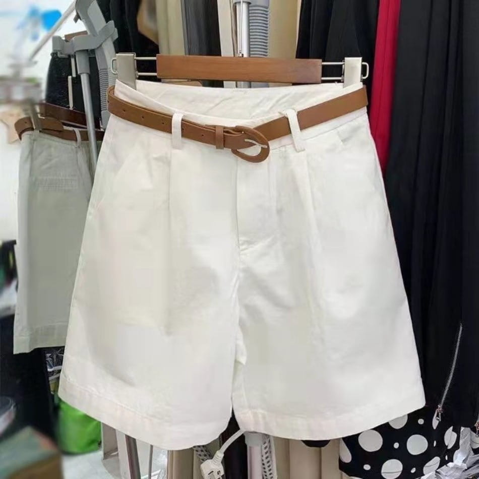 Women casual wide leg summer shorts in white pleated fabric with a tan leather belt featuring a circular buckle.