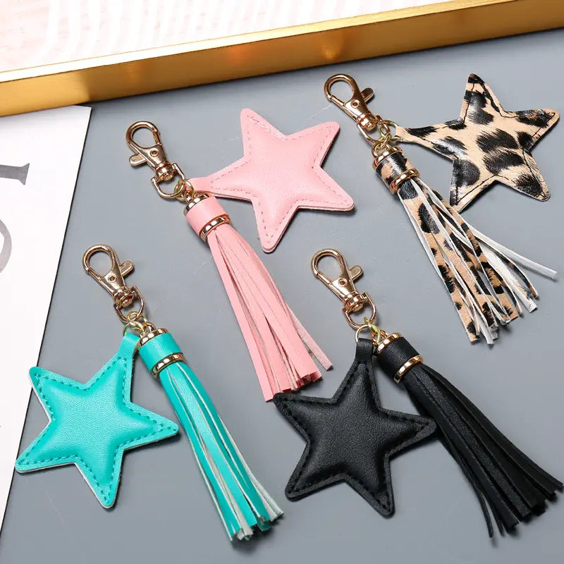 Pink star-shaped leather keychain for women with matching pink tassel and gold-tone metal clasp.