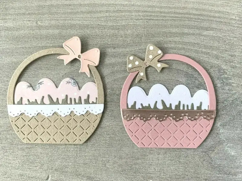 two pastel-colored paper cutout baskets in beige with a pink bow and soft pink with a gold polka-dot bow created using easter egg flower basket metal cutting dies.