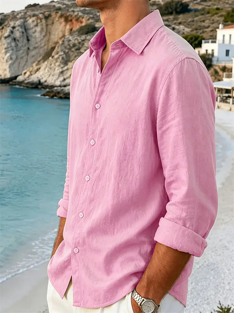 Un homme portant une chemise rose clair pour homme en coton et lin à manches longues, avec col classique et poignets retroussés.